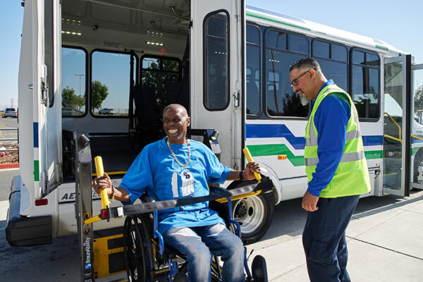 Man getting on to the bus in a wheelchair, using a lift