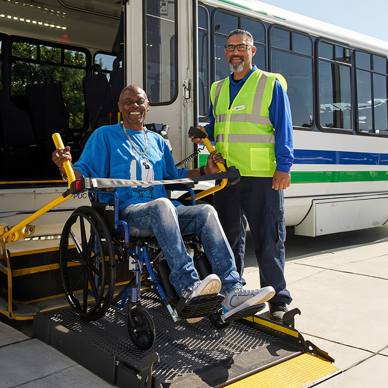 A man is lifted in his wheelchair into the paratransit bus