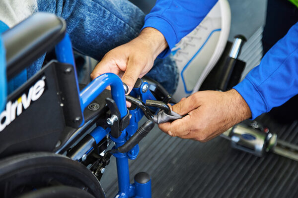 Close up of hands buckling in a wheelchair on a bus