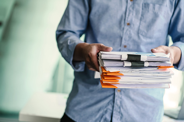 A man holding a stack of papers