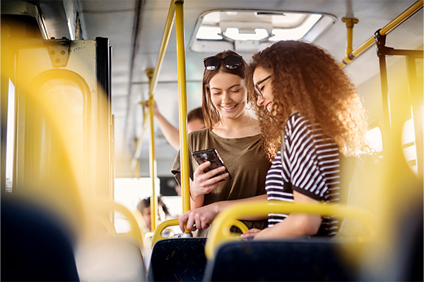 People using their cell phone on a bus