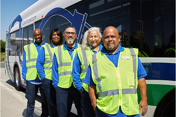 Employees of Tri Delta Transit in front of a bus