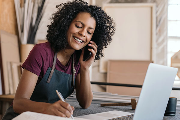 An entrepreneur woman smiling while talking on the phone.