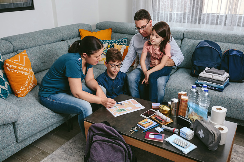 A family sits in their living room going over emergency plans