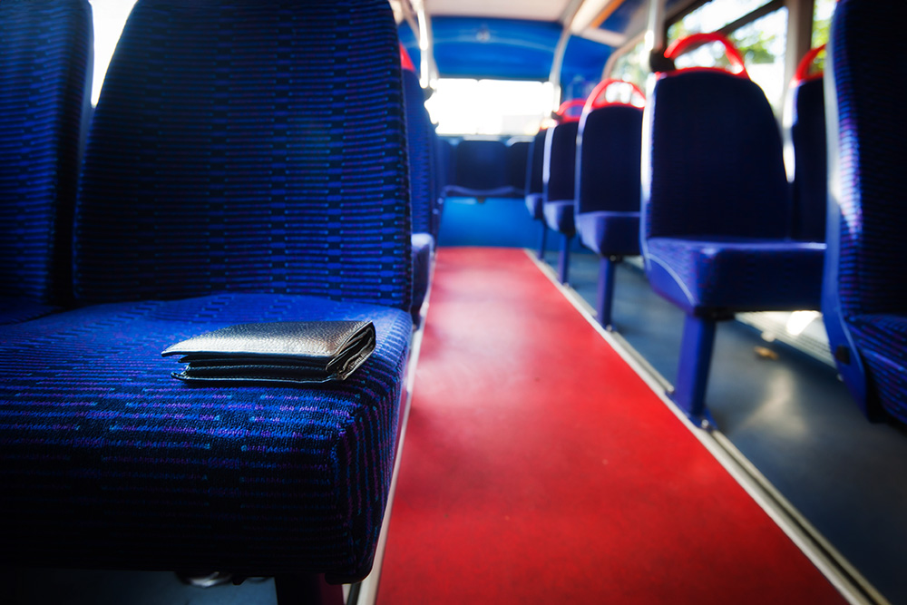 Bus seat with a wallet left on it.