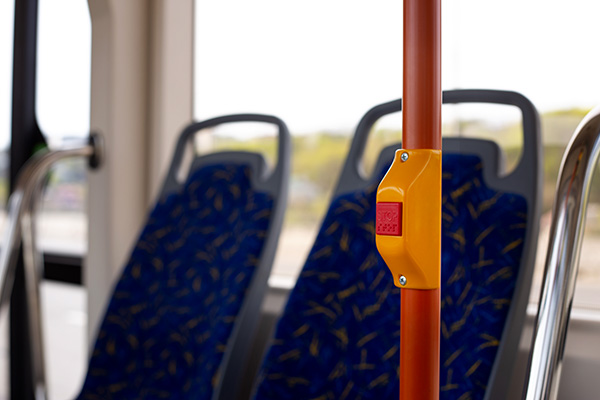 Handrail in city transport with button to stop. stop button in modern public transport with braille text for disabled people