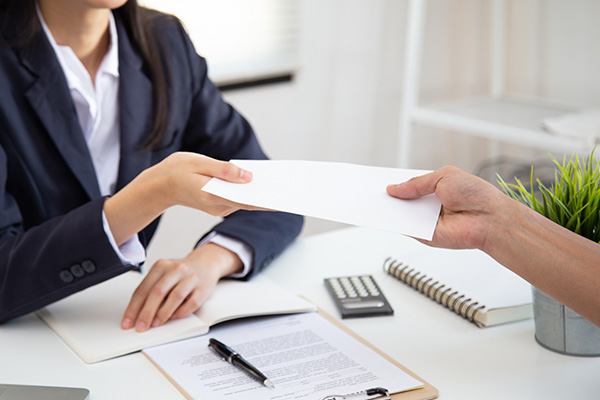 A woman handing a person a refund