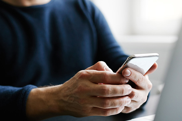 hand of a man using a cell phone