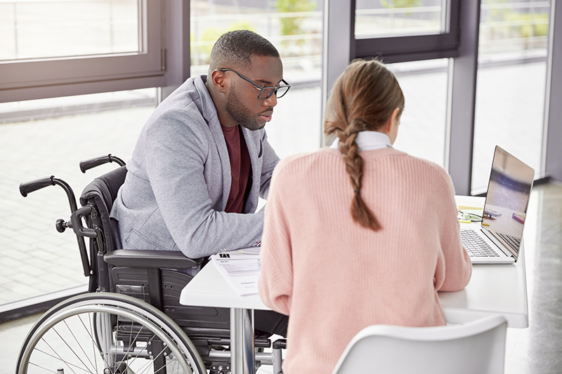 A man in a wheelchair on a computer