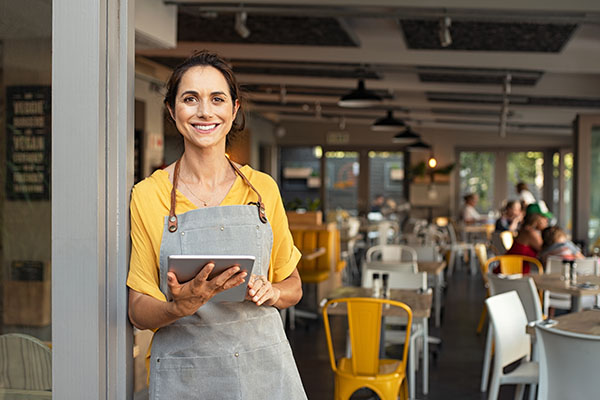 woman in front of business holding clipboard