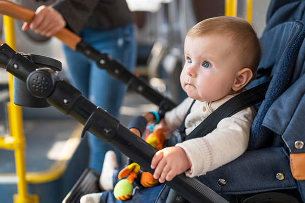 A baby in a stroller, on the bus.